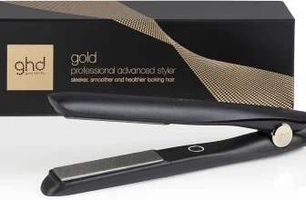 Ein schwarzes Glätteisen mit goldenen Elementen liegt vor seiner Verpackung