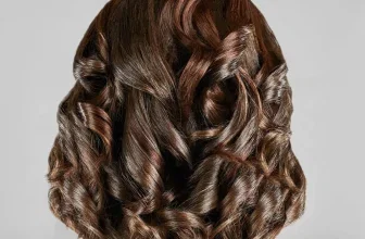 Rückansicht von braunen, gewellten Haaren mit dem Text 'PERFEKTE LOCKEN' oben im Bild.