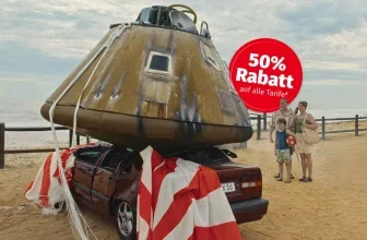 Ein Auto mit einem aufgesetzten, raketenähnlichen Objekt, daneben eine Familie am Strand