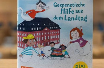 Kleines Mädchen liest Pixi-Buch „Gespenstische Hilfe aus dem Landtag“ im Wohnzimmer