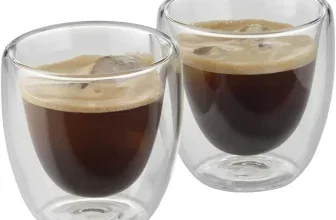 Zwei doppelwandige Gläser mit dunklem Kaffee und Schaum auf weißem Hintergrund