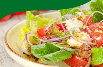 Ein Salat mit Tomaten, Zwiebeln und Salatblättern in einer weißen Schüssel