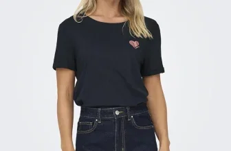 Eine Frau trägt ein schwarzes T-Shirt mit einem rosa Herz-Logo und eine dunkle Jezi