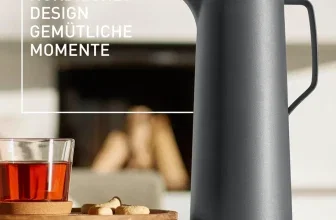 Graue Emsa Motiva Isolierkanne neben Teeglas auf Holztablett mit Text 'NORDISCHES DESIGN GEMÜTLICHE MOMENTE'.