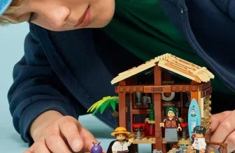 Kind mit blauer Kappe baut LEGO One Piece Hütte im Windmühlendorf mit Minifiguren und Boot