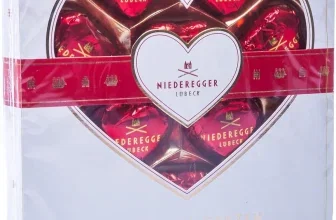Weißes Geschenkbox-Set mit herzförmigem Fenster, das rote Niederegger Marzipan-Herzen zeigt.