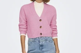 Eine junge Frau trägt eine rosa Strickjacke und eine Jeansrock.