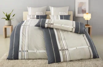 Ein beiges Bett mit grauer, weißer und brauner Bettwäsche