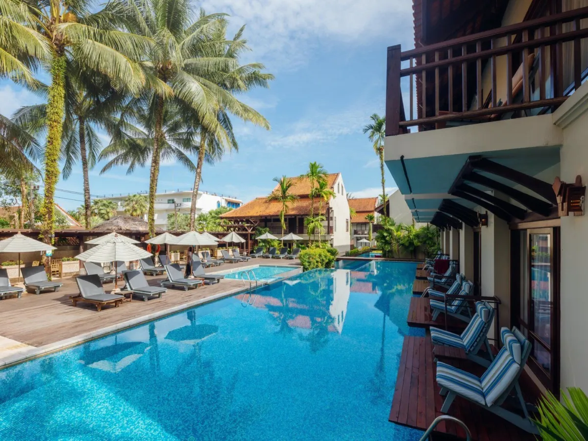 Pool mit Palmen und Liegestühlen