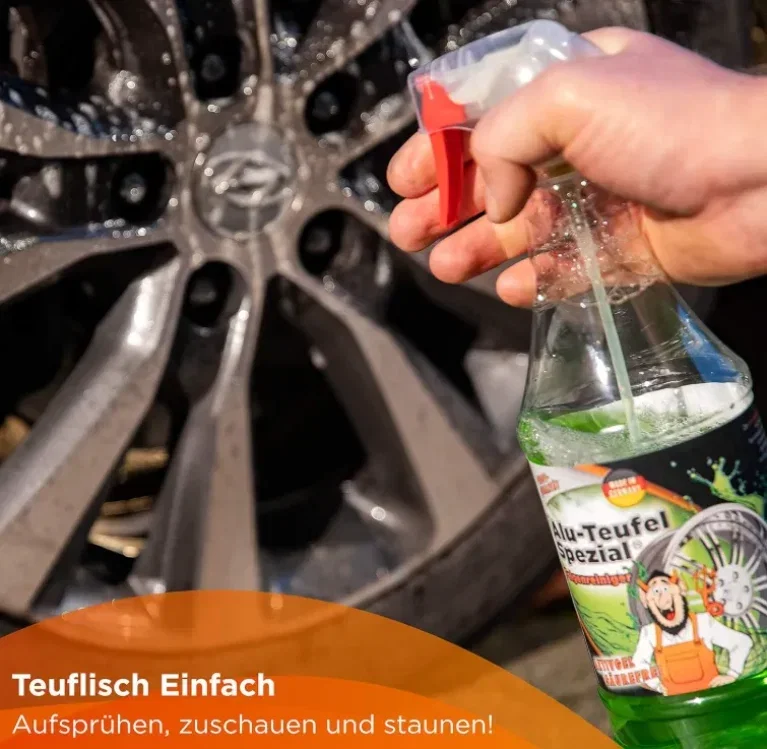 Eine Hand hält einen grünen Felgenreiniger, sprüht auf eine verschmutzte Felge