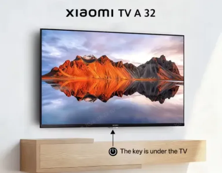 Xiaomi TV A 32 an der Wand mit Berglandschaft auf dem Display und Hinweis auf die versteckte Taste