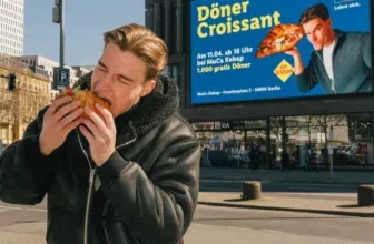 Ein Mann isst ein Döner-Croissant auf der Straße in Berlin