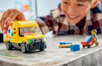 Junge spielt mit gelbem LEGO Van und Minifiguren auf einem Tisch