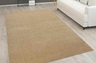Beiger Teppich in einem Wohnzimmer mit weißem Sofa und hellem Holzboden
