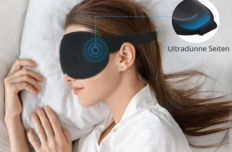 Eine Frau liegt auf dem Rücken und trägt eine schwarze Schlafmaske, die ihre Augen bedeckt. Sie hat ein weißes Hemd an und liegt auf einem weißen Kissen.
