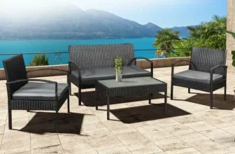 Eine Sitzgruppe aus Polyrattan auf einer Terrasse mit Blick auf das Meer und Berge