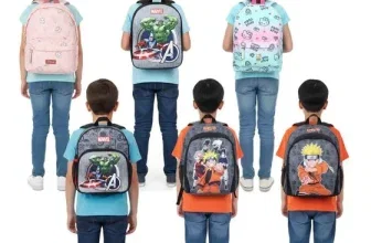 Sechs Kinder stehen mit dem Rücken zur Kamera und zeigen verschiedene bunte Rucksäcke.