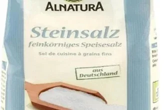 Ein Beutel Alnatura Steinsalz mit 500g Inhalt, vorne ein Löffel voll Salz