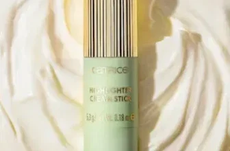 Ein grüner Highlighter-Stift mit goldener Kappe liegt auf einer weißen Creme