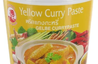 Ein Behälter mit gelber Currypaste, auf dem ein Bild von Currygerichten und Gemüse abgebildet ist.