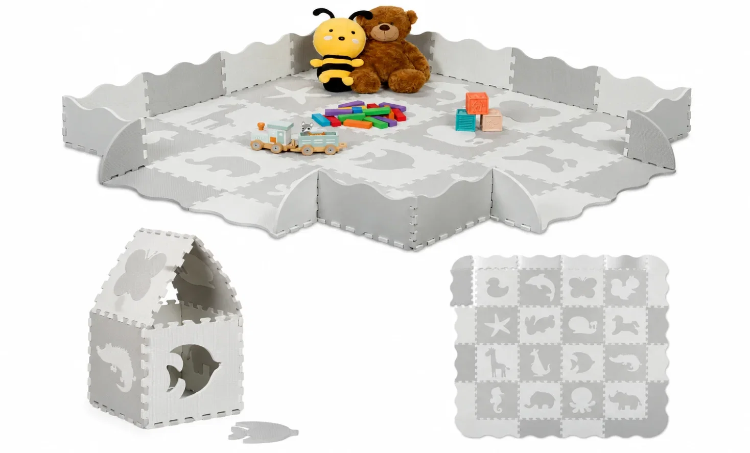 Eine Puzzlematte mit Tiermotiven in Weiß/Grau, im Bild sind ein Teddybär, ein Bienenplüsch und Spielzeug zu sehen