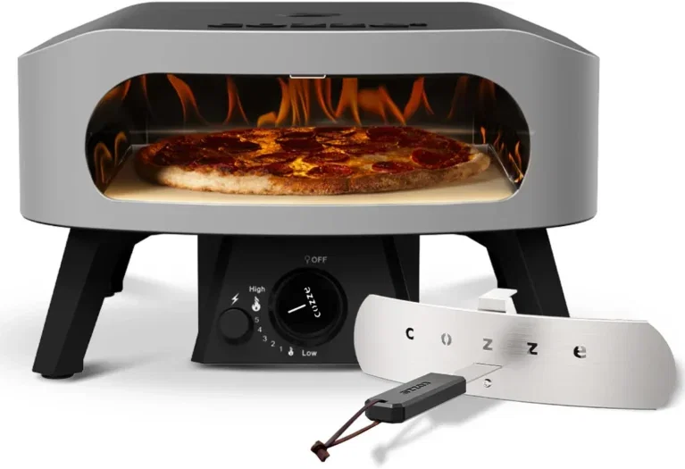 Ein grauer Pizzaofen mit geöffneter Front, darin eine Pizza, daneben ein Pizzaschaber