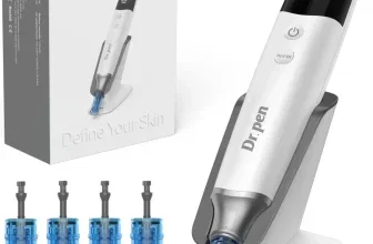 Ein Dermapen mit digitaler Anzeige und austauschbaren Aufsätzen, im Vordergrund steht das Gerät auf einem Ständer, im Hintergrund ist die Verpackung zu sehen.