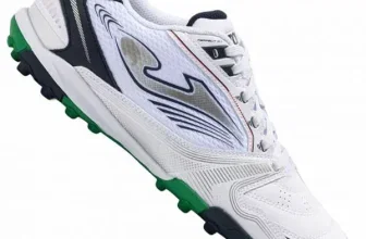 Ein weißer Fußballschuh mit grünen, schwarzen und orangen Akzenten