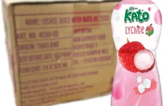Ein rosa Getränkebecher mit weißem Deckel und einer Abbildung von Litschis und Nata de Coco, daneben eine braune Kartonage.
