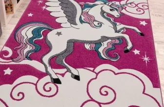 Ein pinkfarbener Teppich mit einem weißen Einhorn, das auf Wolken und Sternen schwebt.