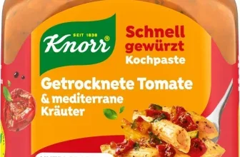 Ein Glas Knorr Schnell gewürzt Kochpaste mit grünem Deckel und roter-orangefarbener Etikette, auf der ein Bild von Pasta mit Tomatensauce und Kräutern abgebildet ist.