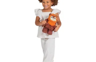 Ein Mädchen hält eine Lego Star Wars Ewok Plüschfigur in den Armen.