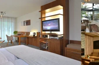Ein modernes Hotelzimmer mit Blick auf den Innenhof, inklusive Fernseher, Schreibtisch und bequemer Sitzgelegenheit.