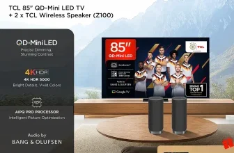 Ein 85-Zoll-TCL-Fernseher mit zwei schwarzen kabellosen TCL-Lautsprechern auf einem runden Holztisch vor einem Sofa.