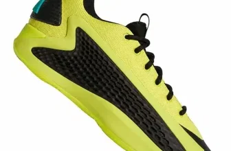 Ein hellgelber Basketballschuh mit schwarzen Akzenten und einer grünen Verzierungen hinten