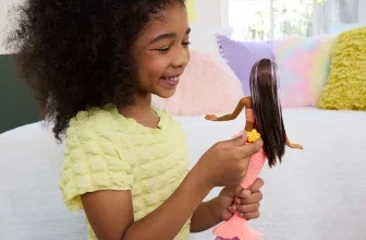 Ein Mädchen hält eine Barbie Meerjungfrau Puppe in den Händen