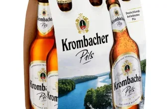 Sechs braune Glasflaschen Krombacher Pils im weißen Karton-Träger mit Landschaftsmotiv und goldenen Kronenkorken