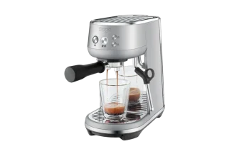 Eine silberne Espressomaschine mit zwei Gläsern darunter, in die Kaffee fließt.