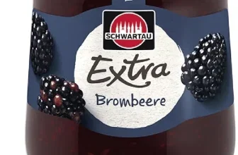 Ein Glas Schwartau Extra Brombeere Konfitüre mit schwarzen Himbeeren und grünem Blatt