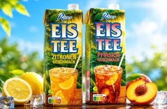 Zwei Tetra Pak Eistee-Packungen mit Zitrone und Pfirsich Geschmacksrichtungen neben Eiswürfeln, Zitronen und Pfirsichen auf einem Holztisch im Freien.