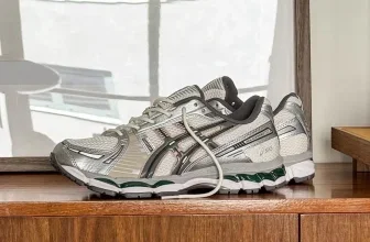 Silberne Asics GEL-1130 Sneaker mit grüner Sohle auf Holzregal