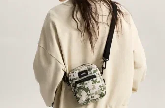 Person trägt eine Vans Bail Umhängetasche mit digitalem Camouflage-Muster und schwarzem Gurt.
