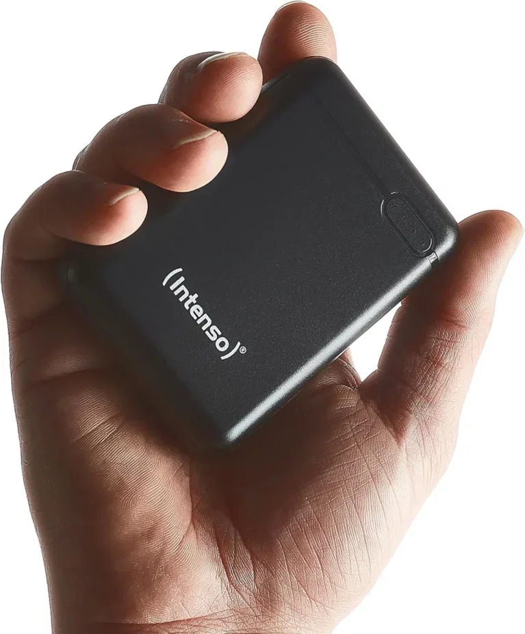 Eine Hand hält eine kleine schwarze Intenso Powerbank XS10000 mit weißem Logo vor weißem Hintergrund.
