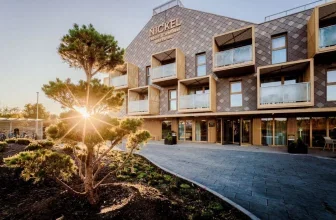 Fassade des Nickel Resort & Wellness Brzozowo mit Balkonen und Sonnenaufgang