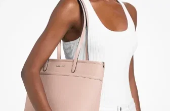 Model trägt eine rosafarbene Michael Kors Marlowe Shopper-Tasche an der Schulter.