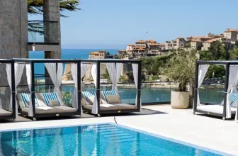 Poolbereich mit Cabanas und Blick auf Meer und Stadt