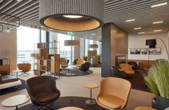 Modernes Interieur der BER Lounge Tegel mit bequemen Sesseln, Tischen und großer Deckenlampe