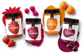 Vier Gläser The Jam Marmelade in Erdbeer, Himbeer, Aprikose und Kirsch mit frischen Früchten