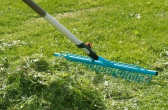 Blauer Gardena Rasenrechen sammelt Grasschnitt auf grünem Rasen