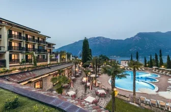 Hotelanlage mit Pool, Palmen und Bergpanorama am Abend